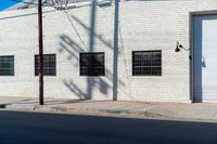 the shadow of a person who is on the sidewalk behind a traffic pole next to an building