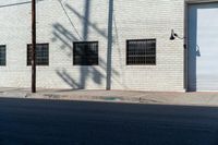 the shadow of a person who is on the sidewalk behind a traffic pole next to an building