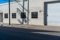 the shadow of a person who is on the sidewalk behind a traffic pole next to an building