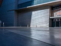 a man standing outside of a modern building on a sunny day as he looks on