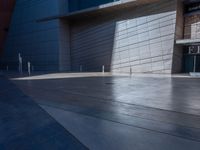 a man standing outside of a modern building on a sunny day as he looks on