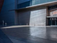 a man standing outside of a modern building on a sunny day as he looks on