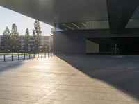 a shadow of someone walking around an empty building in a park with a skateboard