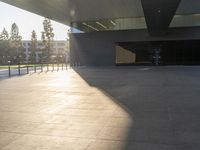 a shadow of someone walking around an empty building in a park with a skateboard