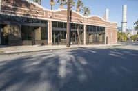 a shadow falls on the street while it passes by an office building on a sunny day