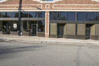 a shadow falls on the street while it passes by an office building on a sunny day