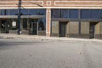 a shadow falls on the street while it passes by an office building on a sunny day