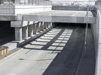 the shadows of two traffic lights on the highway overpasses, and an empty road underneath