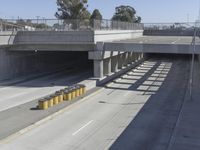 the shadows of two traffic lights on the highway overpasses, and an empty road underneath