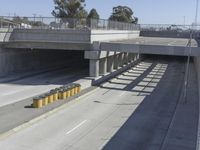 the shadows of two traffic lights on the highway overpasses, and an empty road underneath