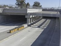 the shadows of two traffic lights on the highway overpasses, and an empty road underneath