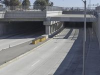 the shadows of two traffic lights on the highway overpasses, and an empty road underneath