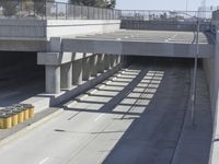 the shadows of two traffic lights on the highway overpasses, and an empty road underneath