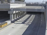 the shadows of two traffic lights on the highway overpasses, and an empty road underneath