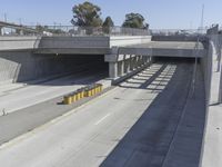 the shadows of two traffic lights on the highway overpasses, and an empty road underneath