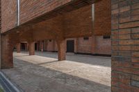 the inside of an empty brick building with red bricks on it and two doors open