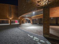 an empty building with a cobblestone street in the middle of the image, and some lights on