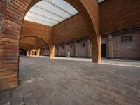 an empty brick building with several windows and arches over it, has a bench on the side