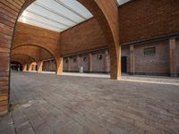 an empty brick building with several windows and arches over it, has a bench on the side