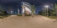 the view of a parking lot from an outdoor bench at night time as seen from fish eye