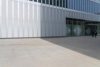 a black car sitting in front of a building with glass doors in it's windows