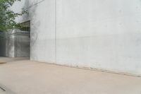 a red fire hydrant sitting in front of a cement building next to a sidewalk