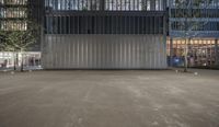 large empty parking lot in urban building at night with lots of lights on its windows