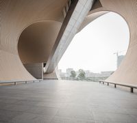 a man riding his skateboard down a cement covered walkway past large building structures and arches