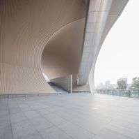 a man riding his skateboard down a cement covered walkway past large building structures and arches