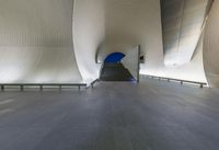 an indoor space with long steps, white fabric and benches on the other side of the walkway