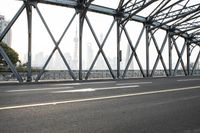 a highway and bridge with buildings in the background and two people walking on it and riding