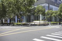 a view of a crosswalk that leads to a building across the street from people