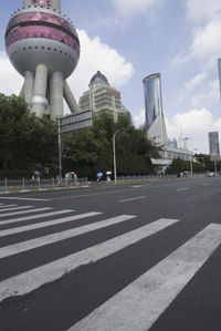 a large building in the city with a pink dome on it's face and some people on a road