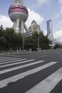 a large building in the city with a pink dome on it's face and some people on a road