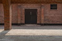 an empty brick walkway with a building in the background and two doors on either side