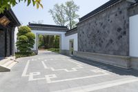 the walkway leads to an outdoor courtyard with large pillars and geometric designs on the walls