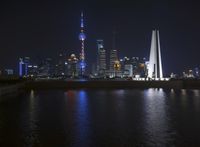 view at night time from the river bank looking toward the city skyline and its tall buildings