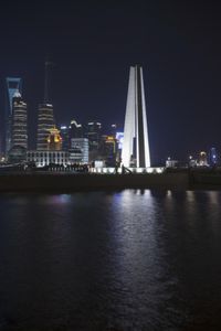 view at night time from the river bank looking toward the city skyline and its tall buildings