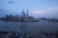 a boat is traveling through a large river next to the city of shanghai, china