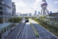 an empty road leading into a city with tall buildings and tall buildings in the background