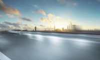 motion bluring view of a highway and city with tall buildings at sunset in the background