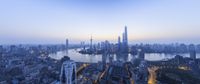 the city skyline of tall buildings in the evening time with blue sky in the background