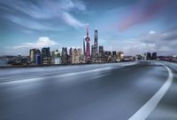 a cityscape, with lots of tall buildings in the background and road running through the foreground