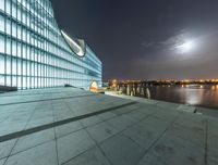 a very large white building that has a big lake in front of it at night