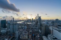 a group of buildings near a river and the city skyline at sunset or sunrise with a lot of buildings