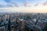 an aerial view of cityscape, and highrises in the distance is cloudy skies