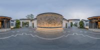 a panoramic photo shows several circular courtyard designs in front of an outdoor fountain