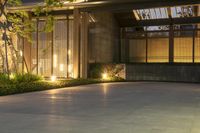 modern home with circular driveway lighting and large front yard in twilight, seen from exterior