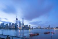 a bridge with several boats in front of a city skyline, at dusk in the distance is an asian river with skyscrapers