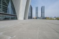 a wide walkway near a building that looks like a futuristic building with curved roof and white walls